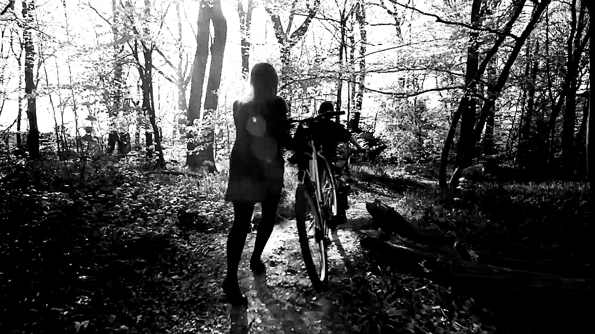 Screenshot of a student film of two people running through the woods in black and white