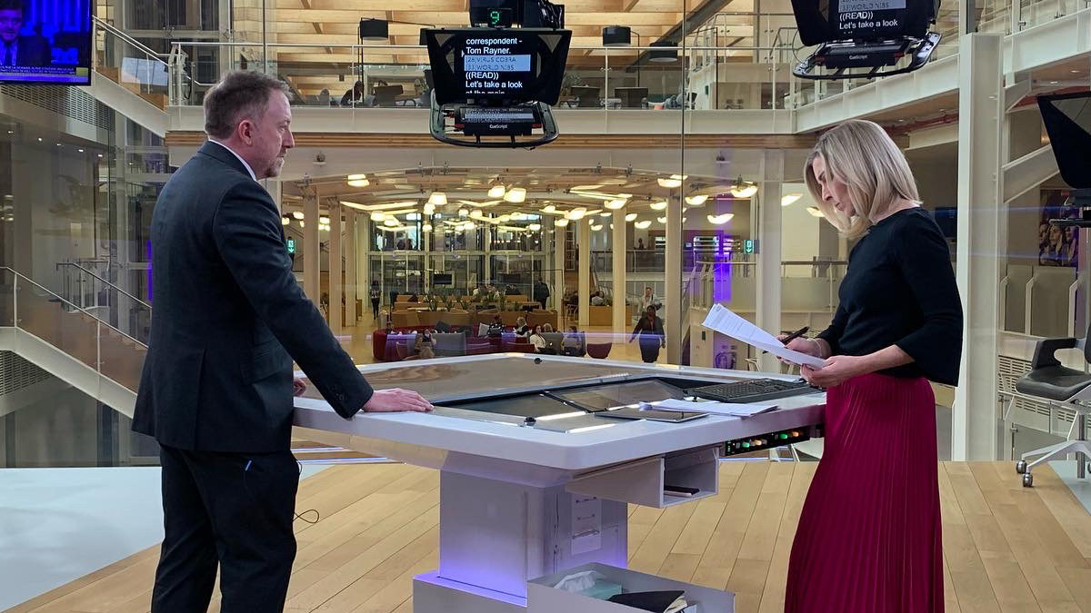 Simon Clarke with a newsreader in a TV studio
