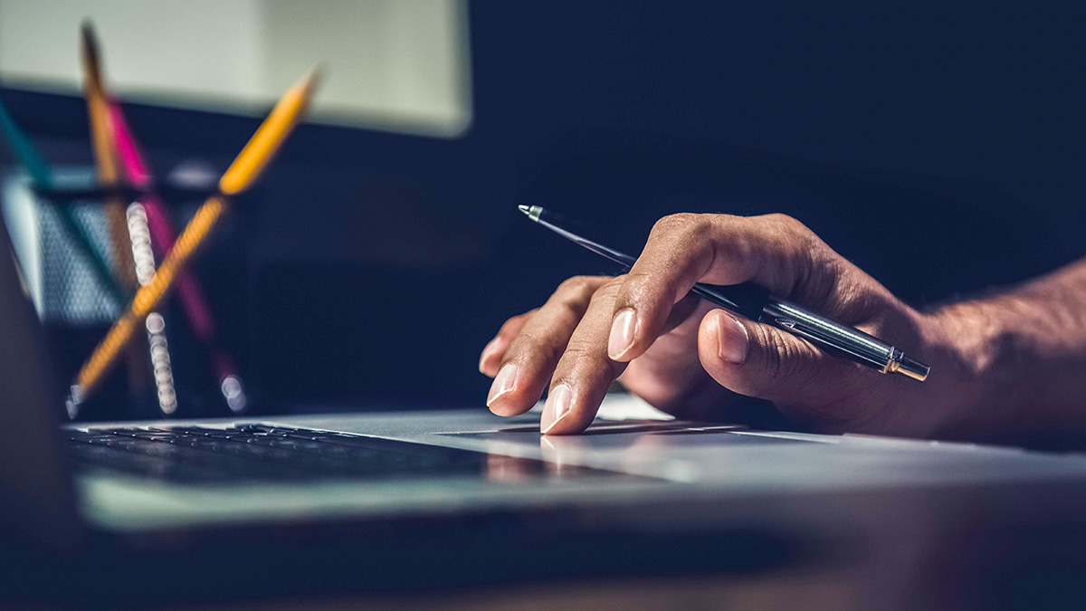 A hand on the track pad of a laptop