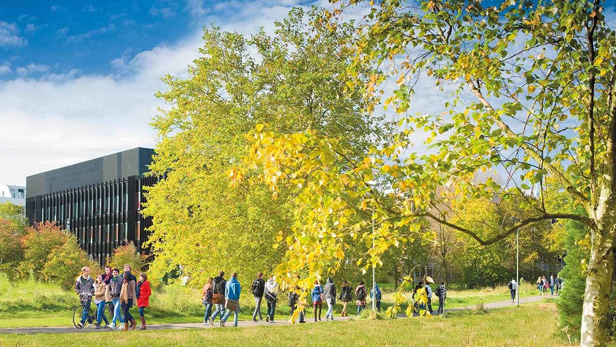 Students walking across campus in front of the Hopkins building